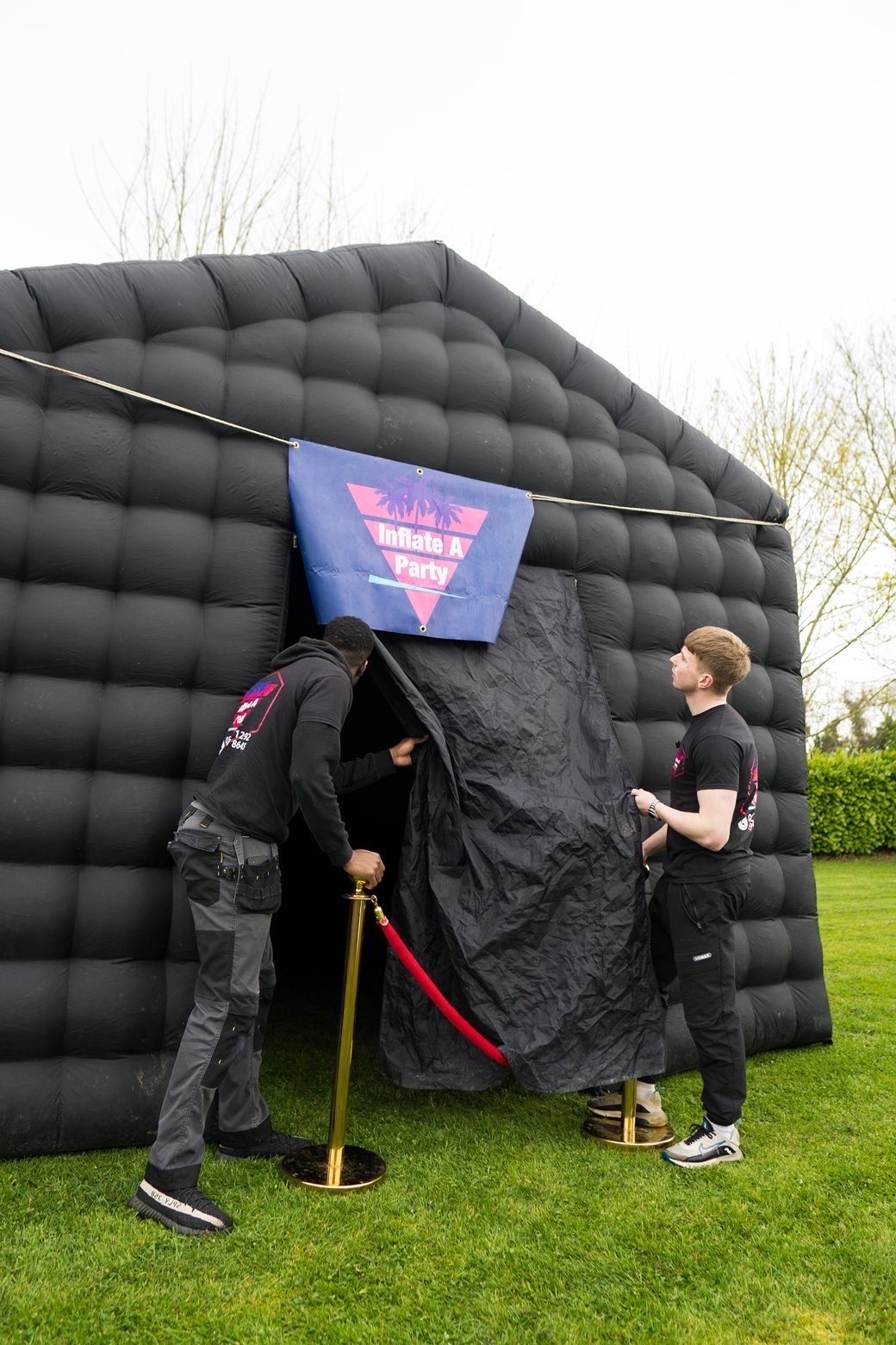 Team setting up the inflatable nightclub entrance with stanchion posts